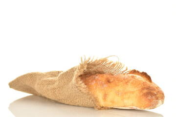One freshly baked French baguette on jute fabric, close-up, isolated on white.