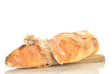 Two delicious freshly baked French baguettes with a jute bag, close-up, isolated on white.