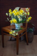Rural still life with bouquet of daffodils on a chair