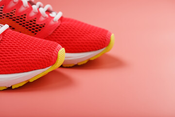 Sports pink sneakers on a pink background with free space.