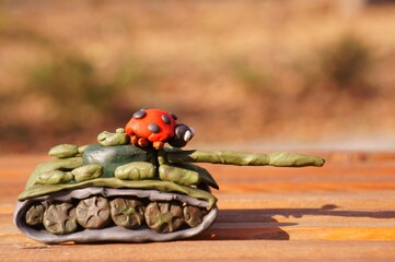 Plasticine tank with ladybug close-up.