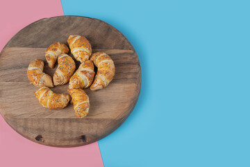 Fried caucasian mutaki cookies on a wooden board on pink blue background
