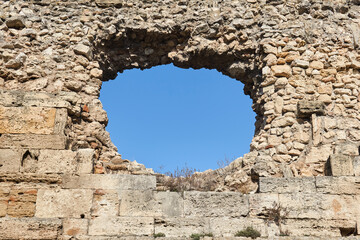 hole in an old medieval fortress wall through which the sky can be seen