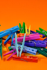 Set of colorful clothespins appearing one by one on an orange background.