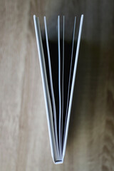 Open book on wooden table. Top view, selective focus.