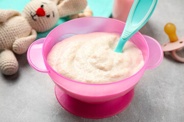 Healthy baby food in bowl on grey table, closeup