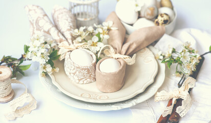 Easter background with Easter eggs and spring flowers. Easter composition with eggs on vintage white plates. Easter bunny napkin gift egg wrapping idea.