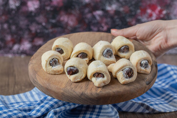 Traditional wrap cookies with strawberry confiture on a wooden board