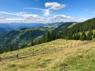 panorama of beautiful cloudy landscape in mountains. grassy field and hills.