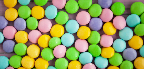 Pastel colored candy on a pink and lilac background, easter background