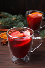 Delicious hot mulled wine on wooden table