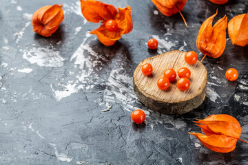 Physalis on wooden stump. Ripe berries of autumn red physalis fruit. berries fruit. Physalis or Chinese Lantern Plants