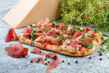 Roman pizza. Sorrentino Pinza with prosciutto, capers and arugula