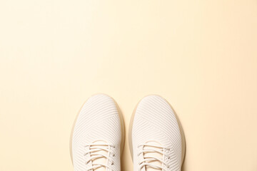 Pair of stylish sport shoes on beige background, flat lay. Space for text