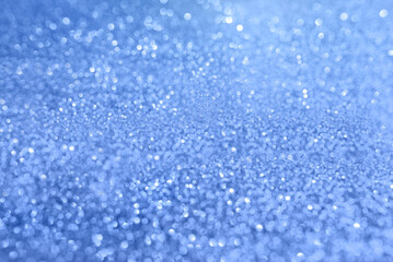 Blue blurred background with highlights and fine texture of shiny crystals