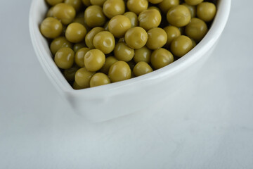 Close up photo of marinated green olives in white bowl