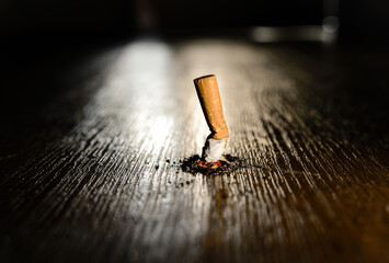 Stop smoking concept. Smoking burning cigarette on a dark background