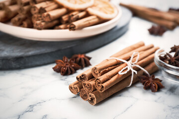 Aromatic cinnamon sticks and anise on white marble table