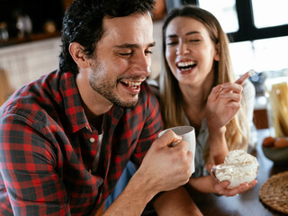 Loving couple drinking coffe in the kitchen. Happy smiling woman enjoy in the morning with her boyfriend.