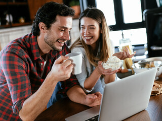 Loving couple drinking coffe in the kitchen. Happy smiling woman enjoy in the morning with her boyfriend.