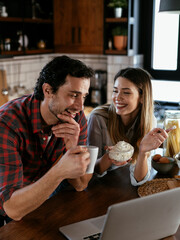 Loving couple drinking coffe in the kitchen. Happy smiling woman enjoy in the morning with her boyfriend.