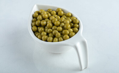 Close up photo of marinated olives in white bowl over white background