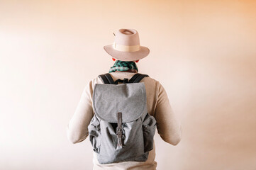 Unrecognizable man from behind with hat and backpack.