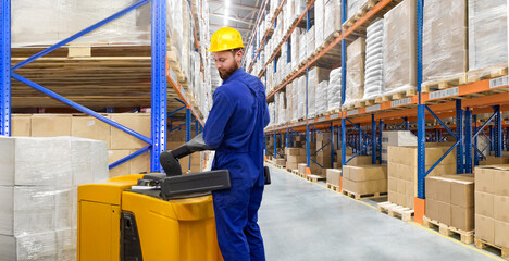 Huge distribution warehouse with high shelves and forklift with young driver. © hacohob