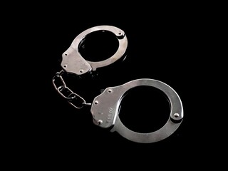 Iron handcuffs on black background
