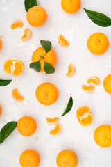 Tangerines: whole, cut and lobules with leaves on white table. Fruit contains many vitamins that are beneficial for healthy lifestyle. Close-up