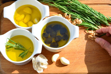 herbs and spices olive oil with garlic olive oil with black olive and walnuts on a wooden board