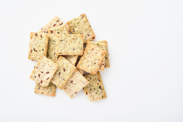 Stack of grain salty crackers with bran and flax seeds on white background. Top view.