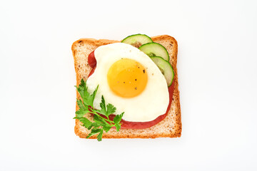 Toast with tomatoes ketchup, cucumber and fried egg isolated on white background, top view.