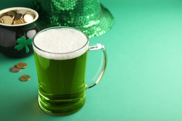 Glass of beer, gold and party hat on green background, space for text. St Patrick's Day celebration