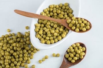 Pile of marinated olives. White ceramic bowl and two wooden spoon