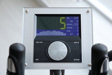 Fototapeta premium Control panel of modern elliptical machine cross trainer on blurred background