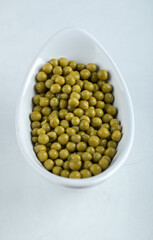 Vertical photo of white bowl full with green olives