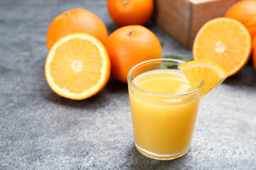 Delicious orange juice and fresh fruit on grey table. Space for text