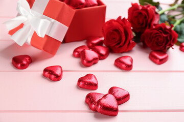 Fototapeta na wymiar Heart shaped chocolate candies on pink wooden table