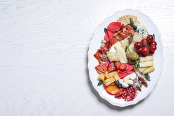 Assorted appetizers served on white wooden table, top view. Space for text