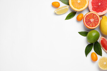 Fresh juicy citrus fruits with green leaves on light background, flat lay. Space for text