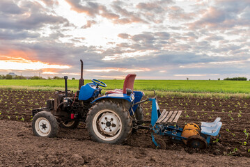 tractor in the middle of a field at sunset rural landscape close-up