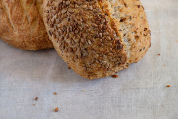 Two loaves of bread from a small bakery on a gray canvas. Sunflower seeds. Crisp. Copy space.
