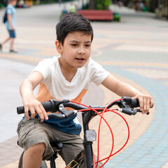 Obraz premium Young boy rids a bicycle outdoors on vacation