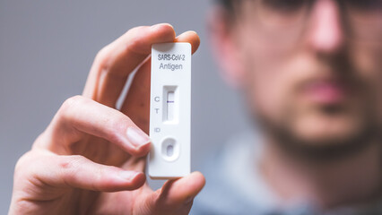 Express corona test at home: Close up of young man holding a negative covid antigen test