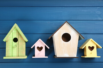 Beautiful bird houses on blue wooden table, flat lay