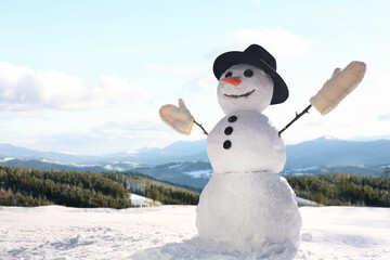 Funny snowman outdoors on sunny day, space for text