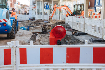 Barrier at a construction site in the city center. construction zone. repairing pipes in the historic center of the city. holes in the pavement for installing pipes. repair works 