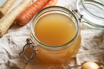 Bone broth in a glass jar, with vegetables
