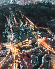 Aerial view Kharkiv city center popular recreation park Sarzhyn Yar with lights illumination. Botanical garden with water spring and playground in evening